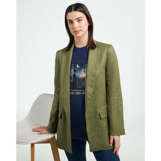 En kvinna i grön blazer bär Eiffeltorn T-Shirt, som visar Paris skyline i nattljus.
