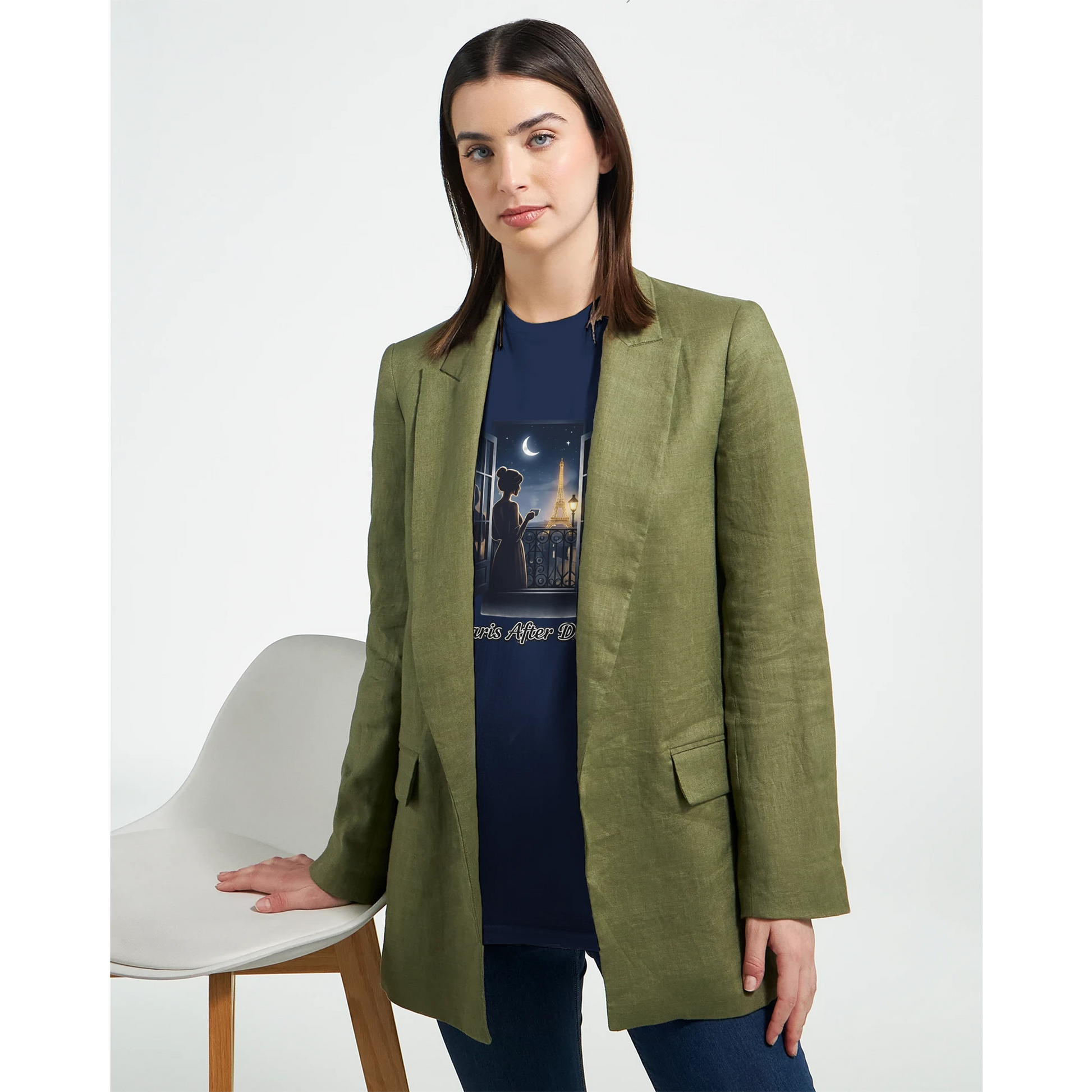 En kvinna i grön blazer bär Eiffeltorn T-Shirt, som visar Paris skyline i nattljus.