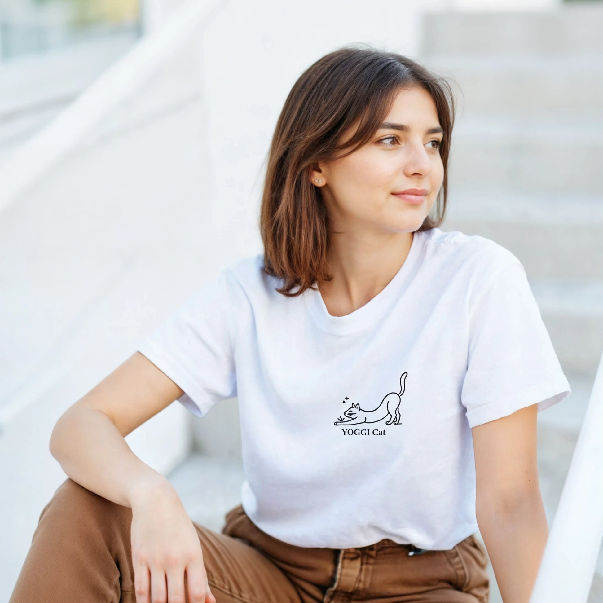 Stretching Cat T-Shirt – kvinna bär en vit t-shirt med minimalistisk kattillustration.