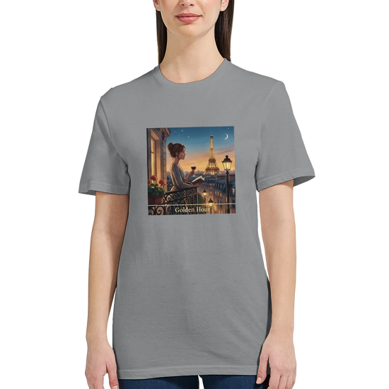Grå t‑shirt med Paris Motiv i Golden Hour design som visar en kvinna på balkongen med Eiffeltornet.