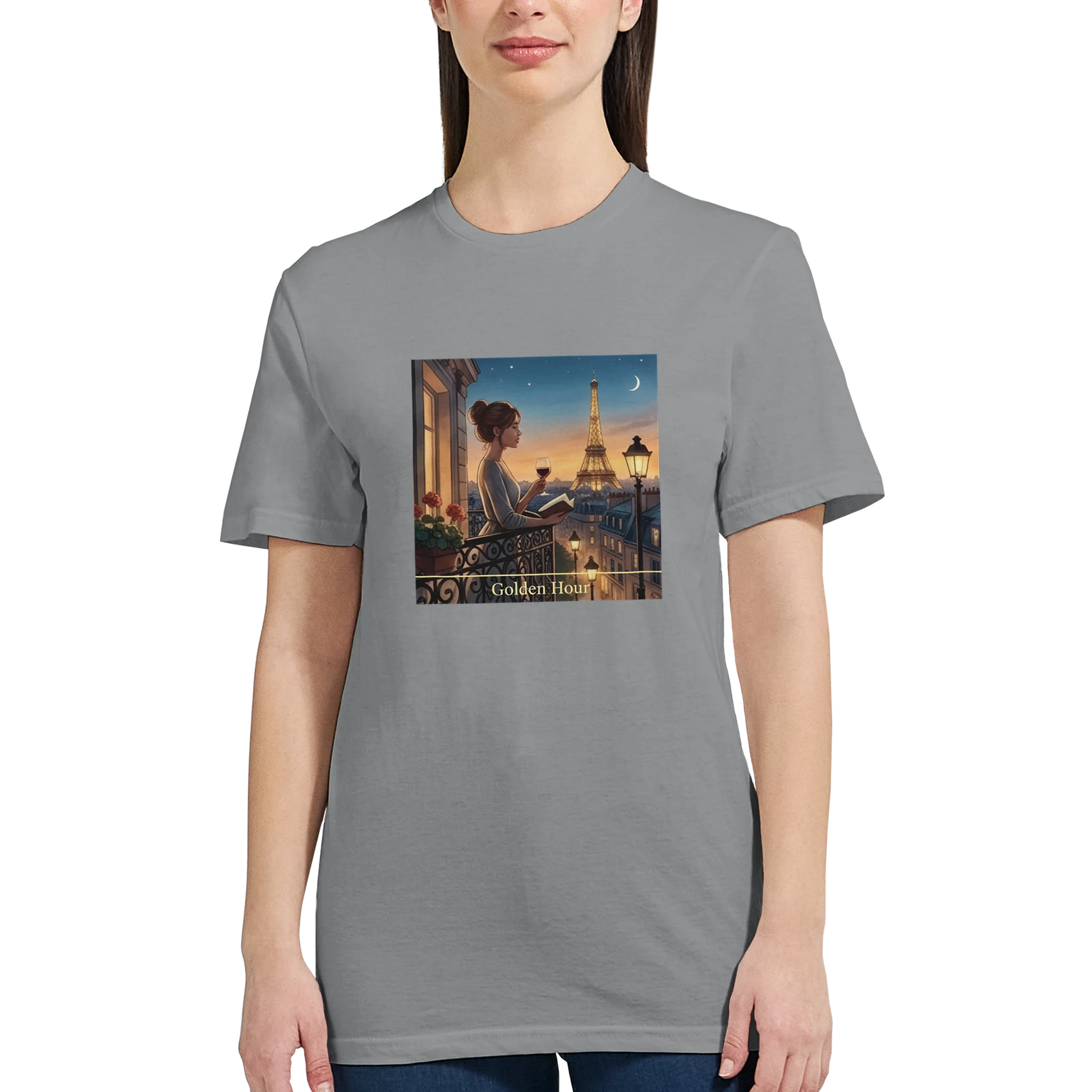 Grå t‑shirt med Paris Motiv i Golden Hour design som visar en kvinna på balkongen med Eiffeltornet.