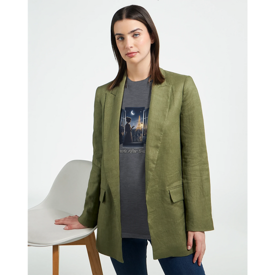 Kvinna i grön blazer med Eiffeltorn T-Shirt, poserar vid en stol, stilren och personlig look.