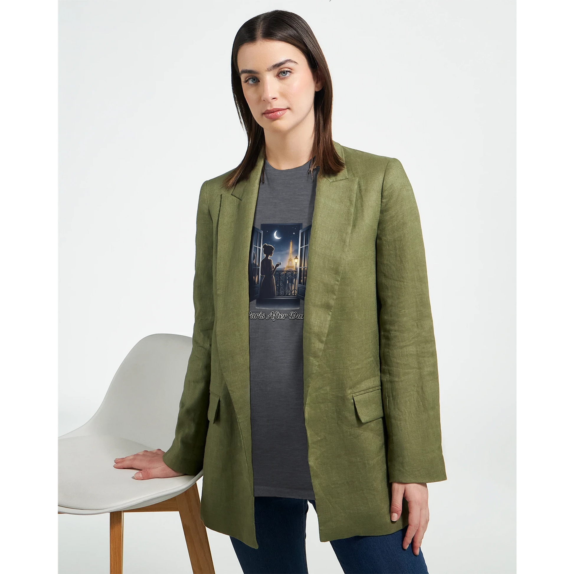 Kvinna i grön blazer med Eiffeltorn T-Shirt, poserar vid en stol, stilren och personlig look.