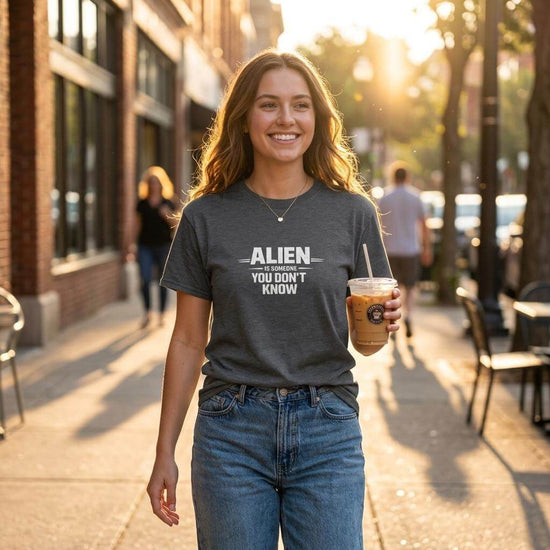 Kvinna som bär Urban Identity Graphic T-shirt med meddelande "ALIEN YOU DON'T KNOW" på en stadsgata