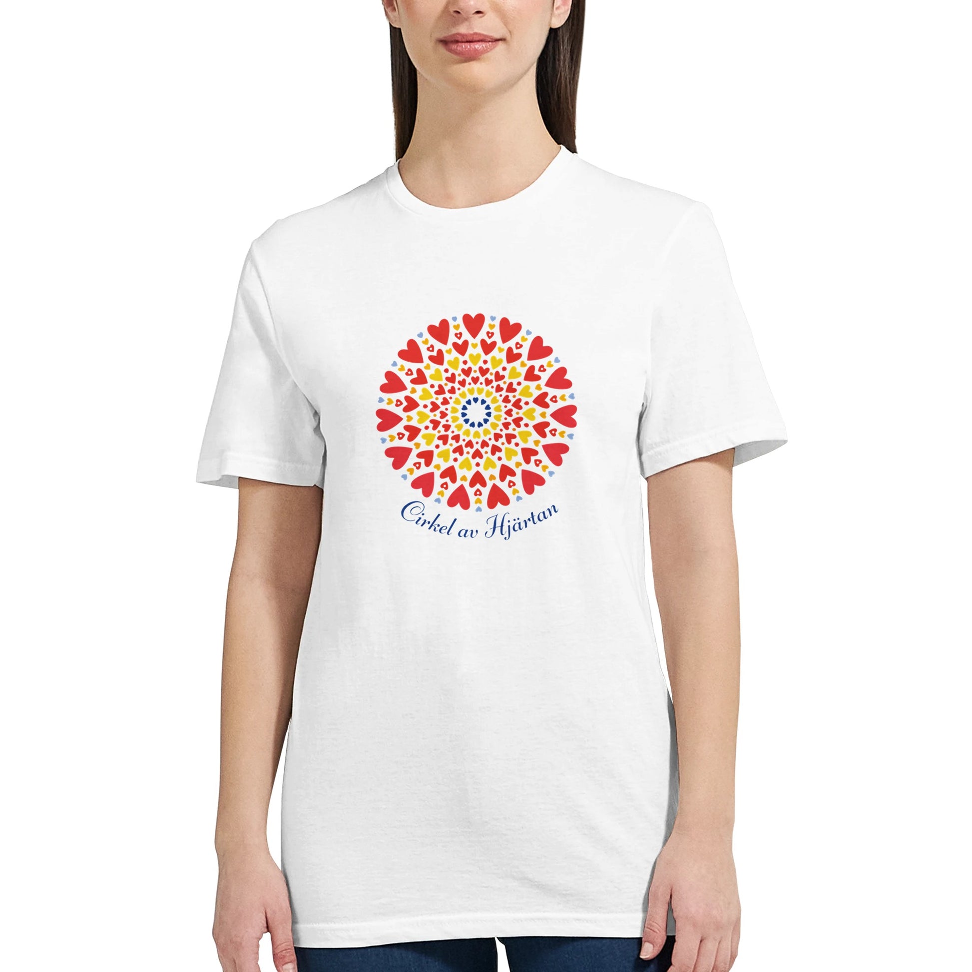 Vit figursydd t‑shirt med ett färgstarkt cirkelmönster av hjärtan i gult, rött och blått, kompletterat med texten ‘Cirkel av Hjärtan’ under motivet.