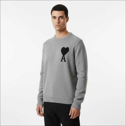 Ami de Coeur stickad tröja i grå ullmix med svart hjärta och bokstaven A, modell stående.