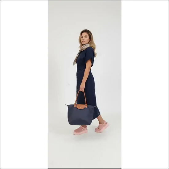 Model showcasing Large Longchamp Tote in navy blue, paired with a stylish outfit and pink shoes.