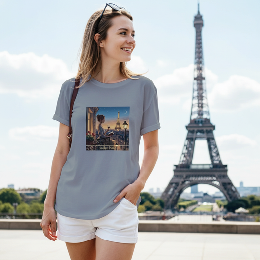 Kvinna som bär en grå t‑shirt med Paris Motiv och Golden Hour design framför Eiffeltornet.