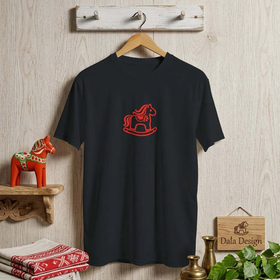 Dalarna Red Rocking Horse T-Shirt hanging on a wooden peg, showcasing minimalist red rocking horse design.