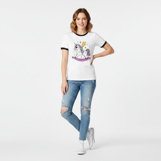 Kvinna i ringer-tshirt med unicorn tryck och blixtar, bär jeans och står framför vit bakgrund.