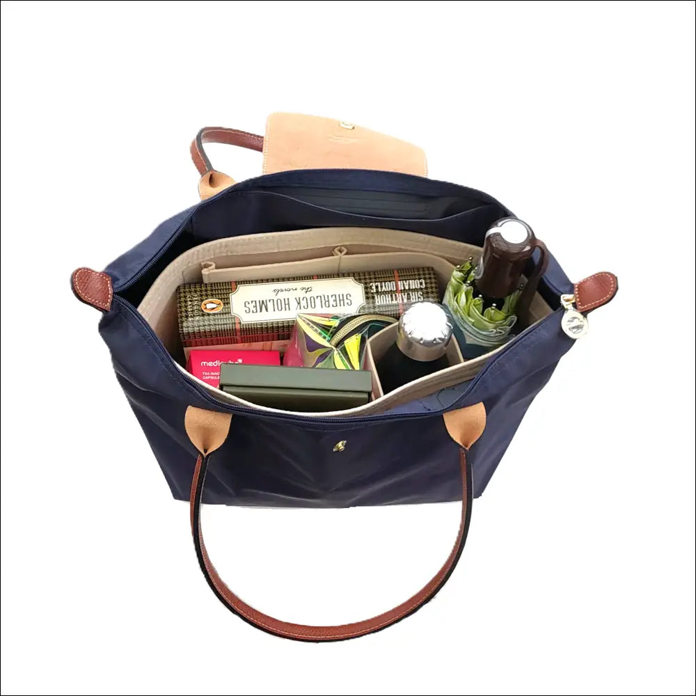 Longchamp organiserare i en handväska med smart förvaring för flaskor och andra tillbehör.