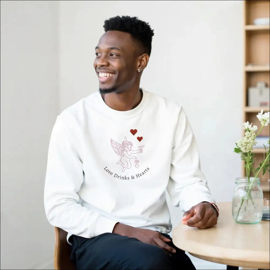 Love Sweatshirt worn by a smiling man, featuring a cute graphic of a winged character with hearts.