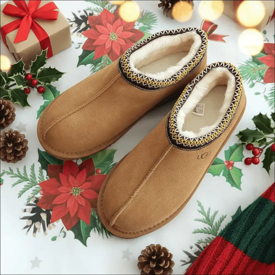 UGG Tasman Chestnut mockatofflor på pyntat bord med juldekorationer och julblommor.