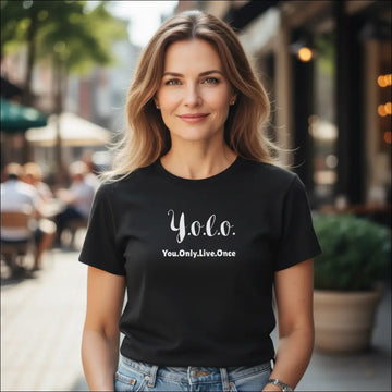 Kvinna bär en svart YOLO You.Only.Live.Once t-shirt i en livlig utomhusmiljö.